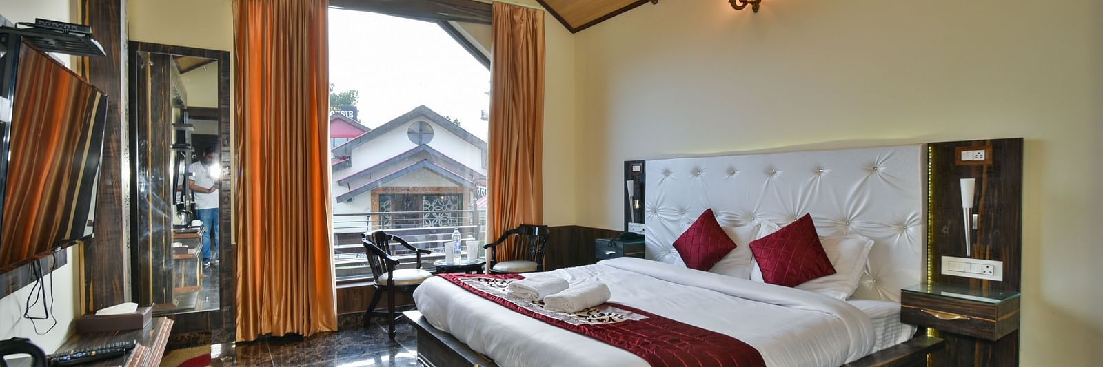 Super Deluxe room at DLS Dalhousie Valley Resort with a  king size bed, a balcony and ambient lighting 